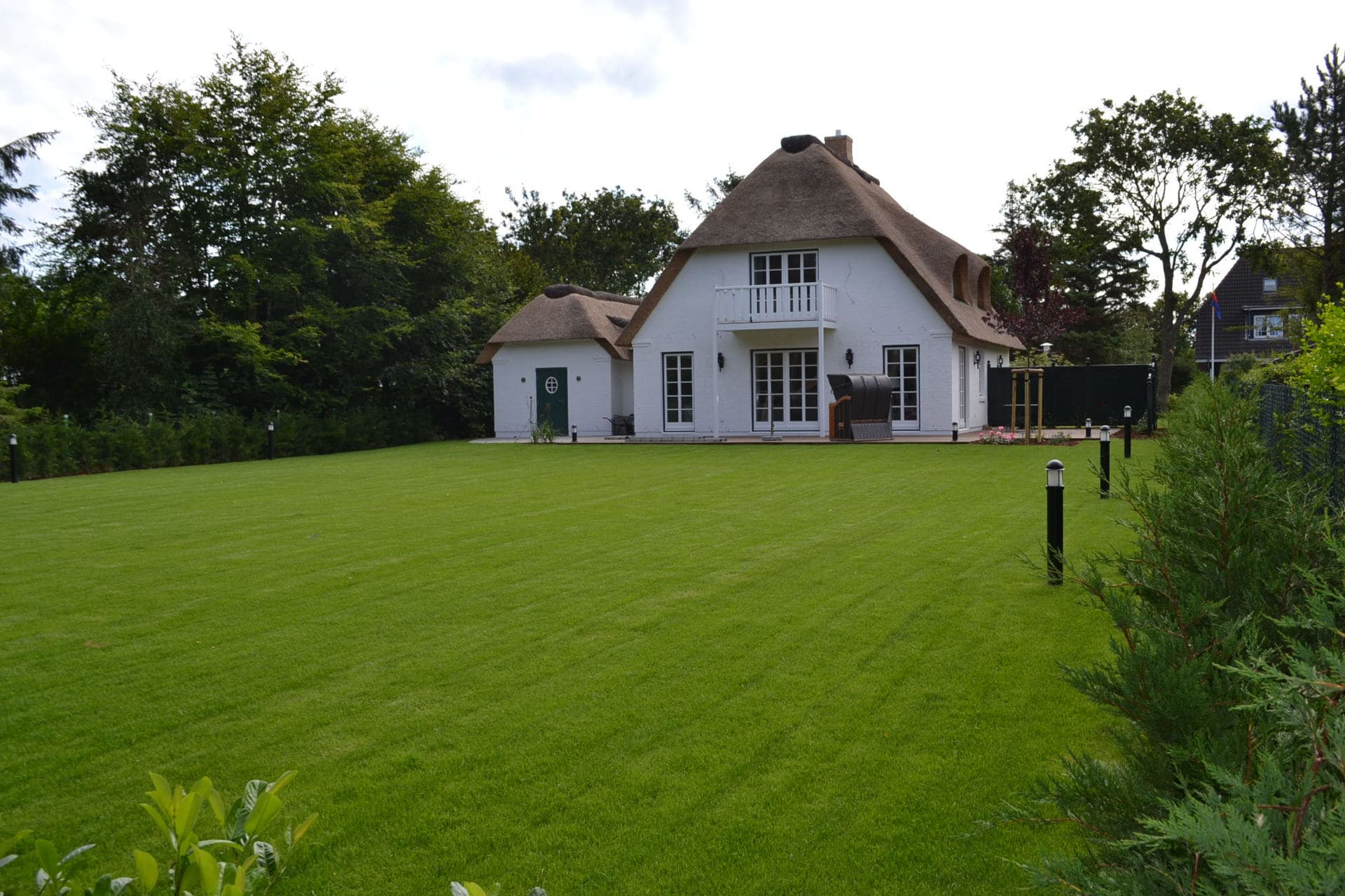 Rasenfläche vor Reetdachhaus